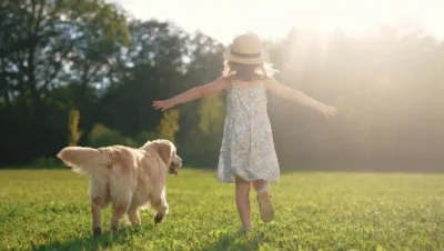 犬と子供が草の上を走る